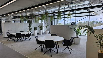 Office space with large windows, desks, tables and plants